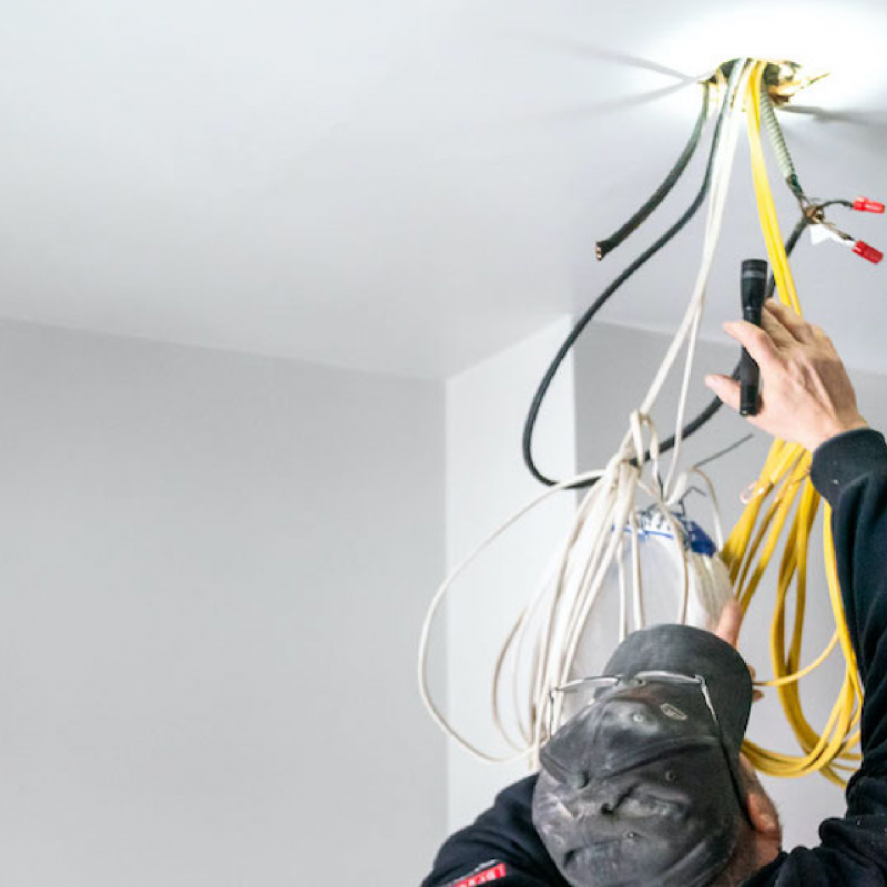 Man rewiring messy cable on ceiling