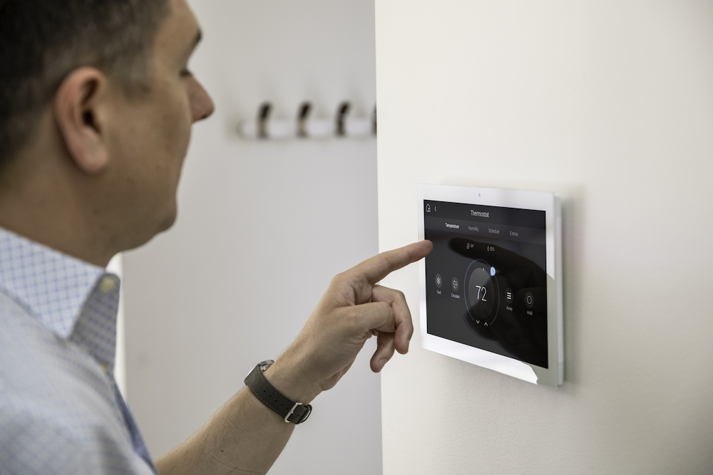 Man touching smart home control panel on a wall