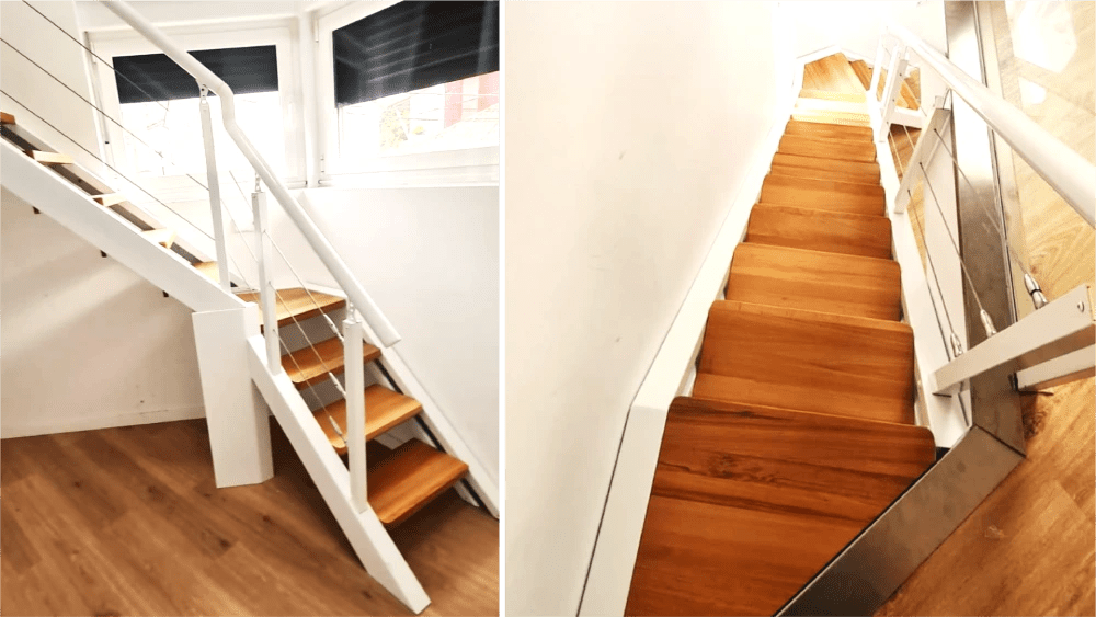 Escaleras factory class de madera con barandillas de metal blancas haciendo esquina en una subida a una segunda planta.