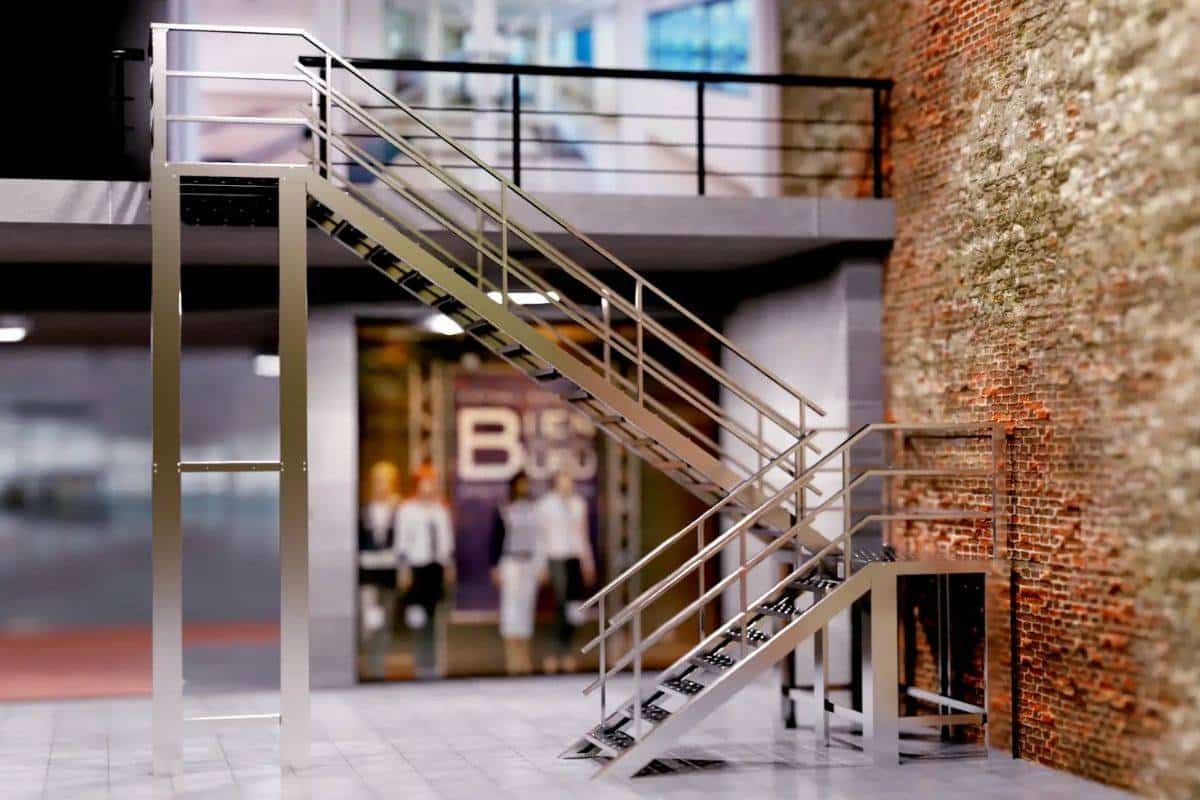Escalera prefabricada para exterior con dos alturas y acabado en acero inoxidable para zona comercial