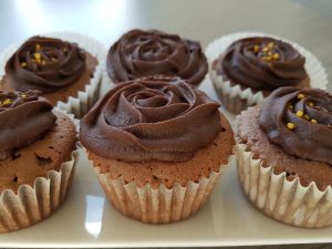Chocolade cupcakes gedecoreerd met chocoladeglazuur en gouden suikerdecoratie