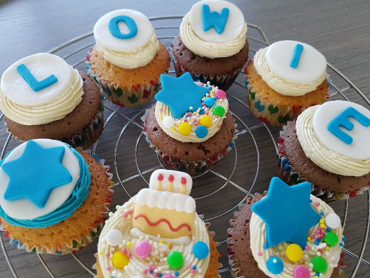 verjaardagscupcakes met botercème en blauwe belettering