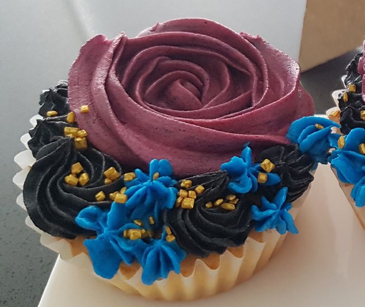 cupcake met paarse botercrème in de vorm van een bloem