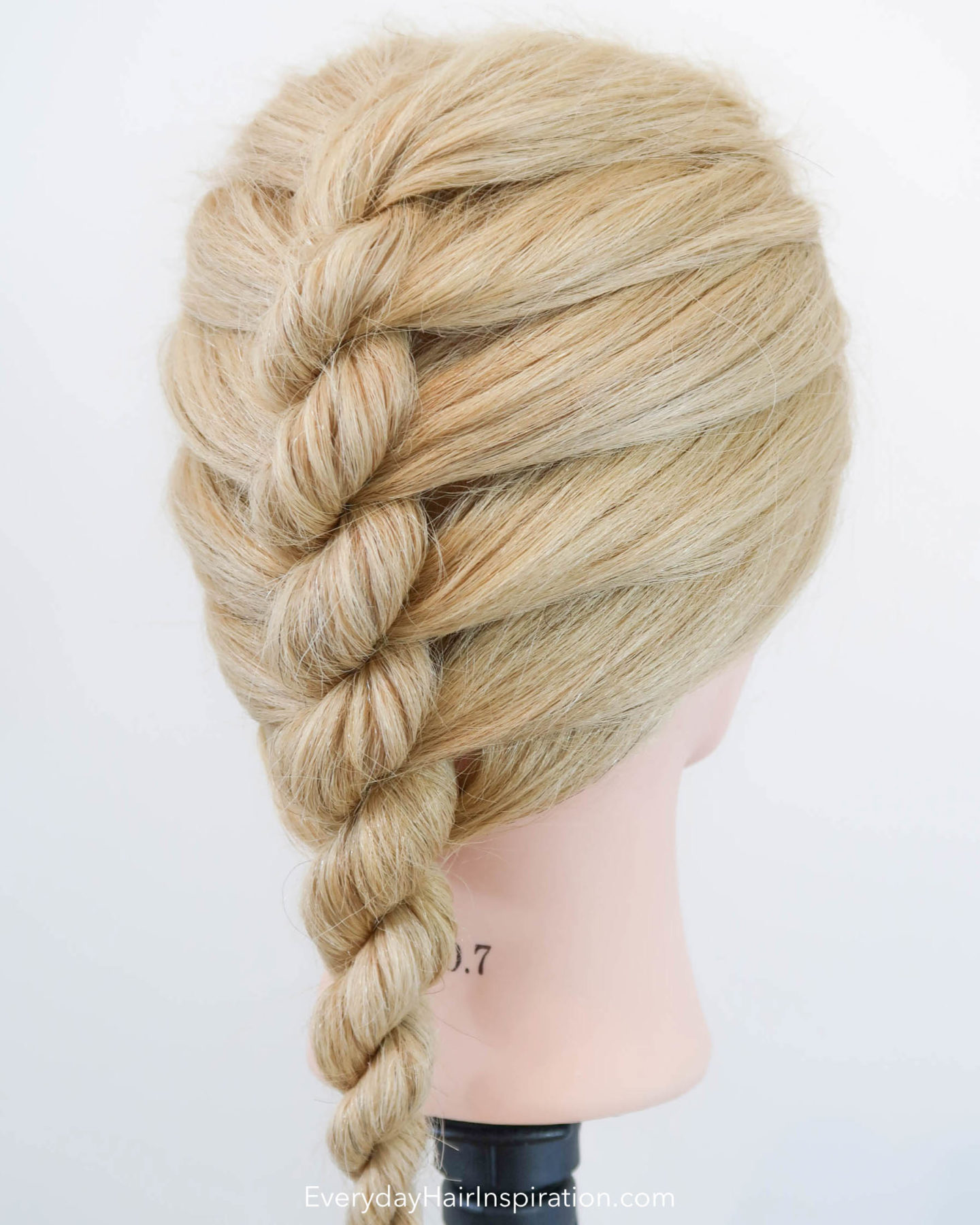 Blonde hairdresser doll with a single french rope braid in the hair - looking at the braid from a side angle.