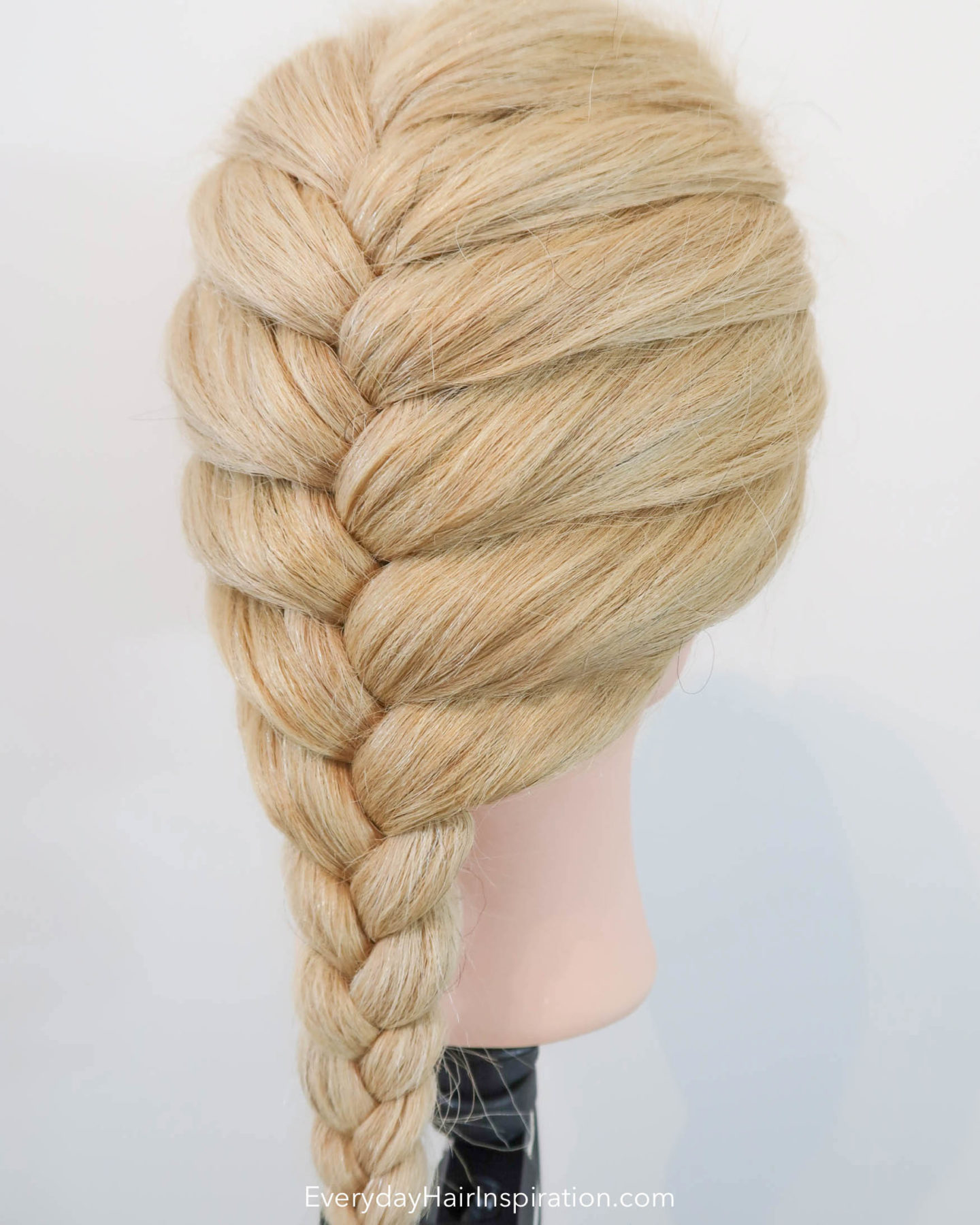 Blonde hairdresser doll. Slight side profile of a single French braid