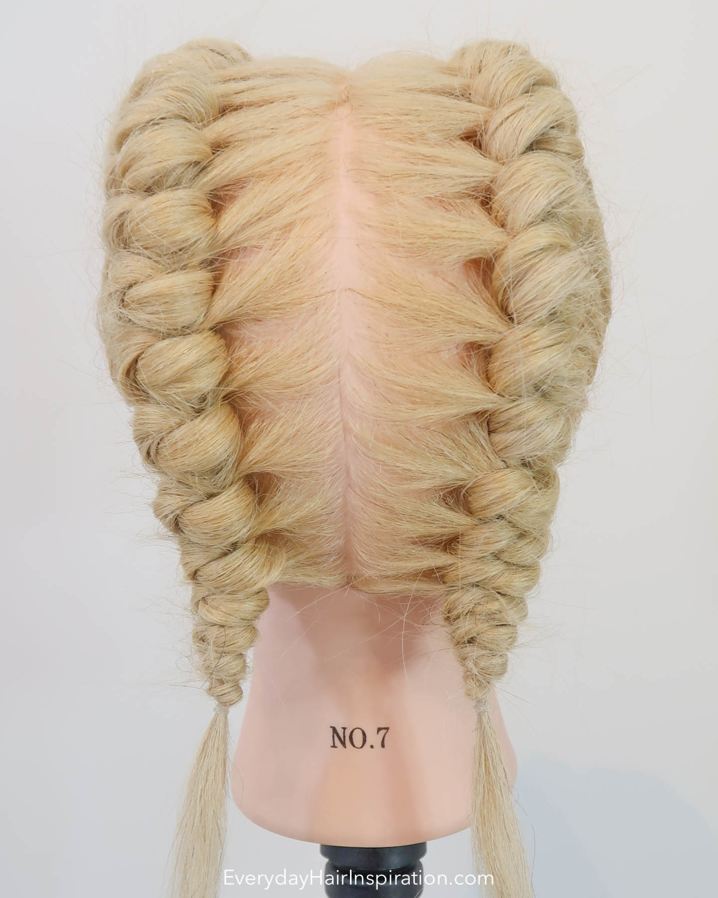 Blonde hairdresser head, seen from the back with double knot braids