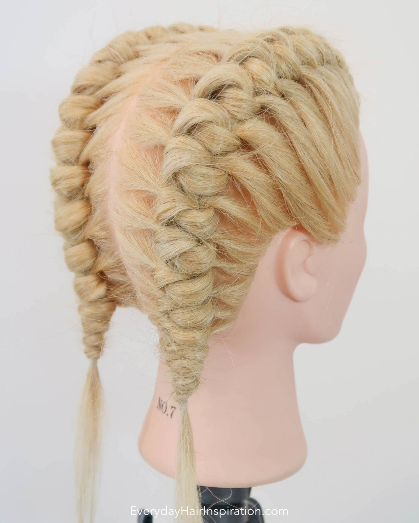Blonde hairdresser head, seen from the side with double knot braids