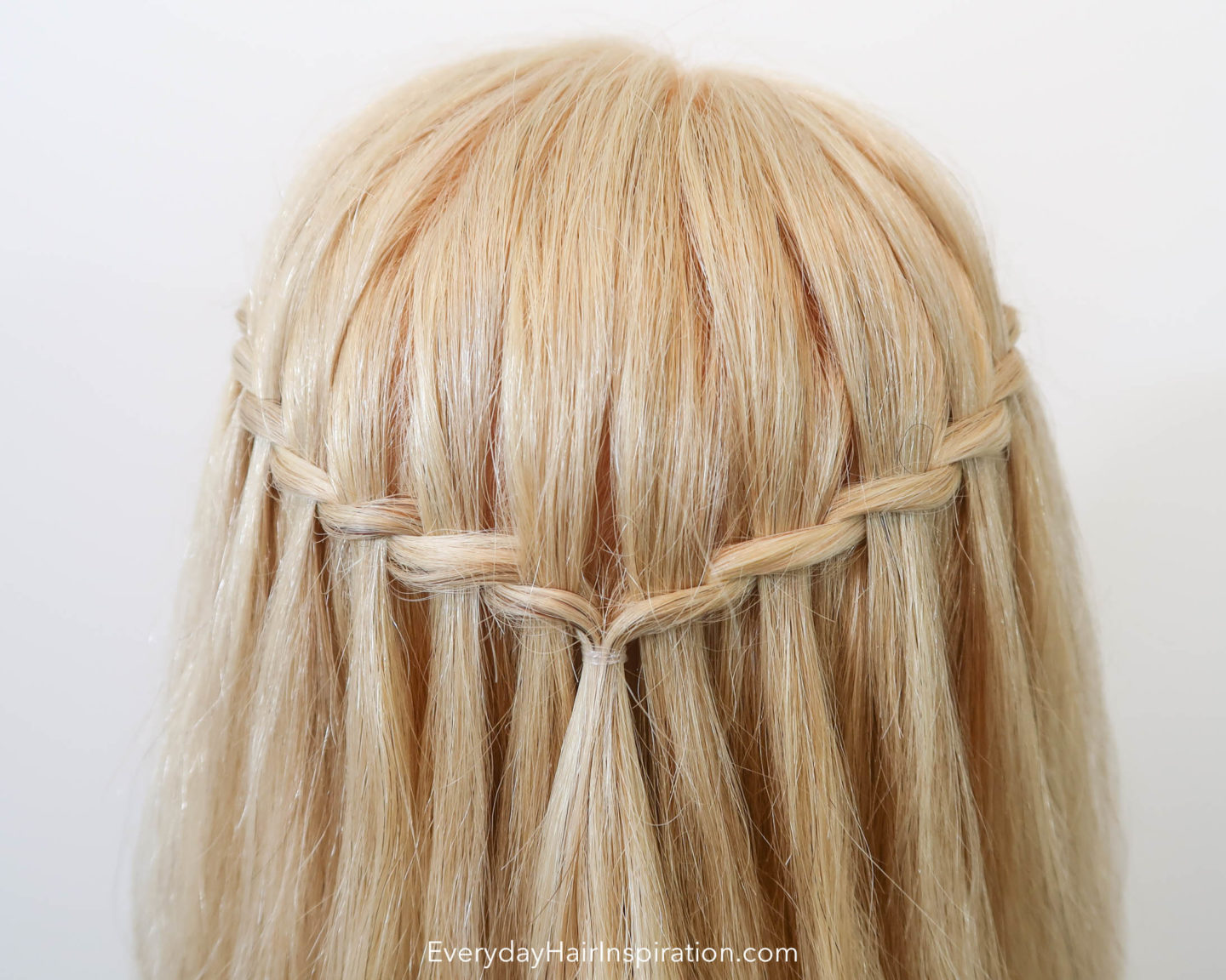 Blonde Hairdresser doll with a twisted waterfall braid in the hair, closeup seen from the back 