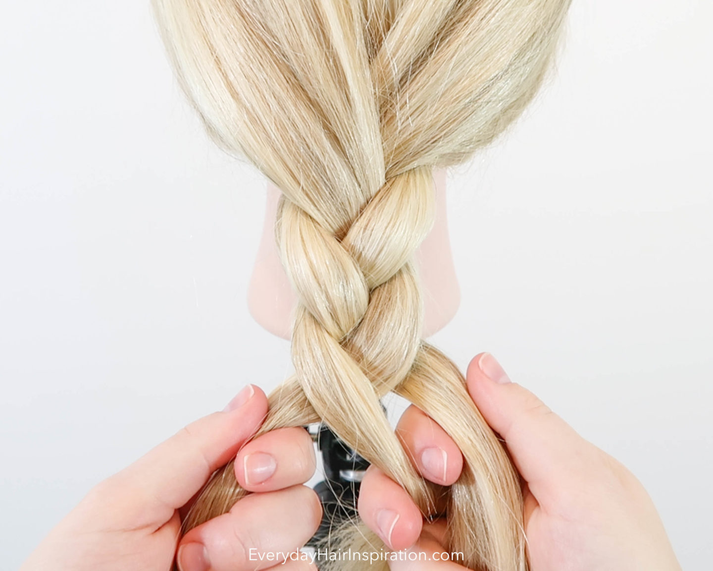 Blonde hairdresser doll with a basic braid getting braided in the hair.