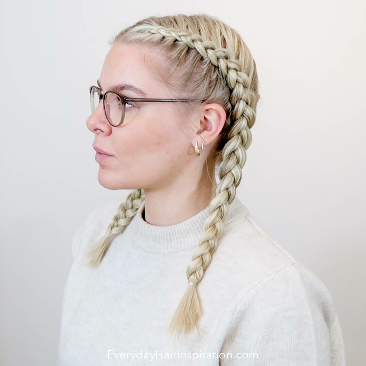 Blonde girl seen from the side with dutch braid in her hair.