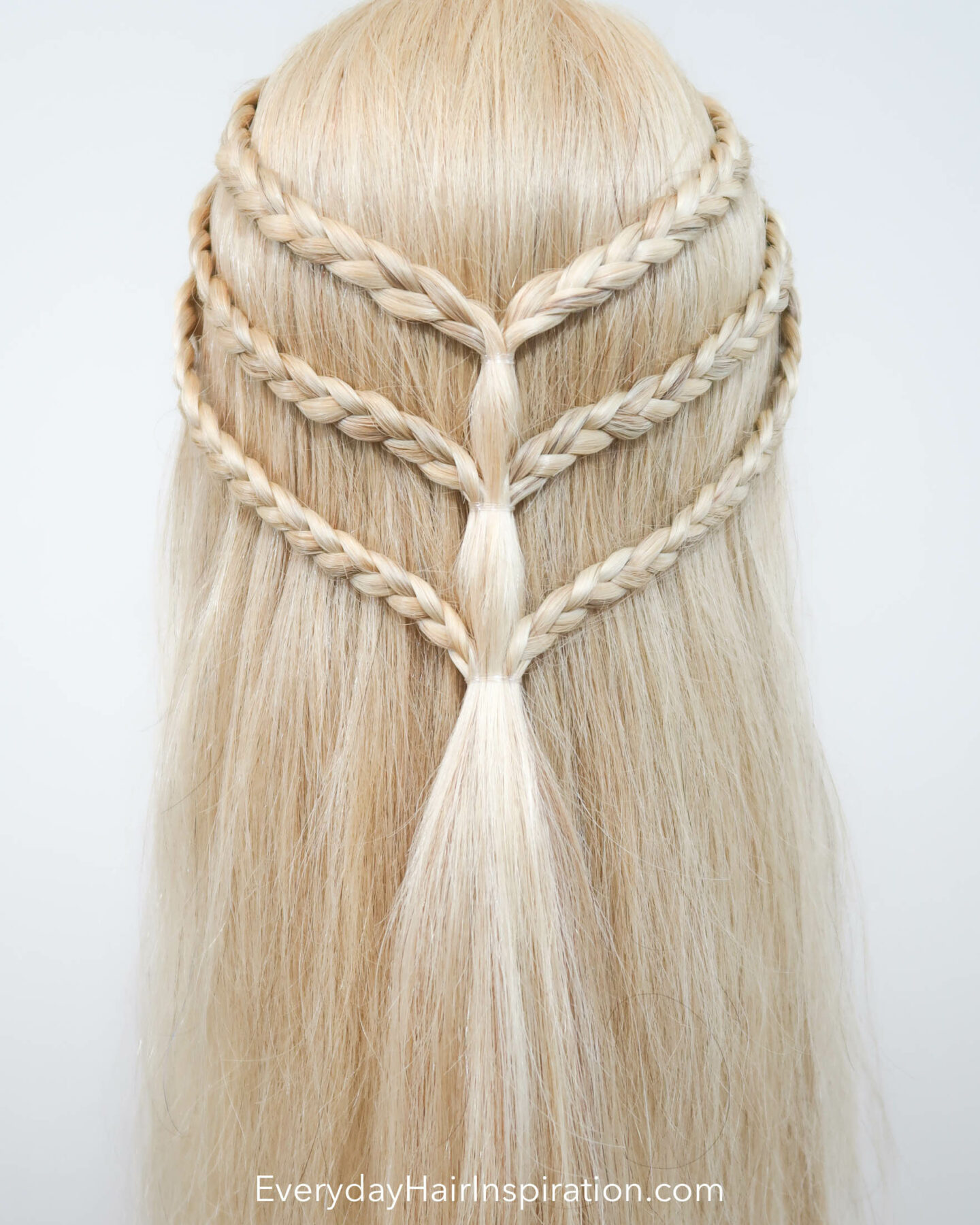 Blonde hairdresser doll with a triple braided half up half down hairstyle seen from the back