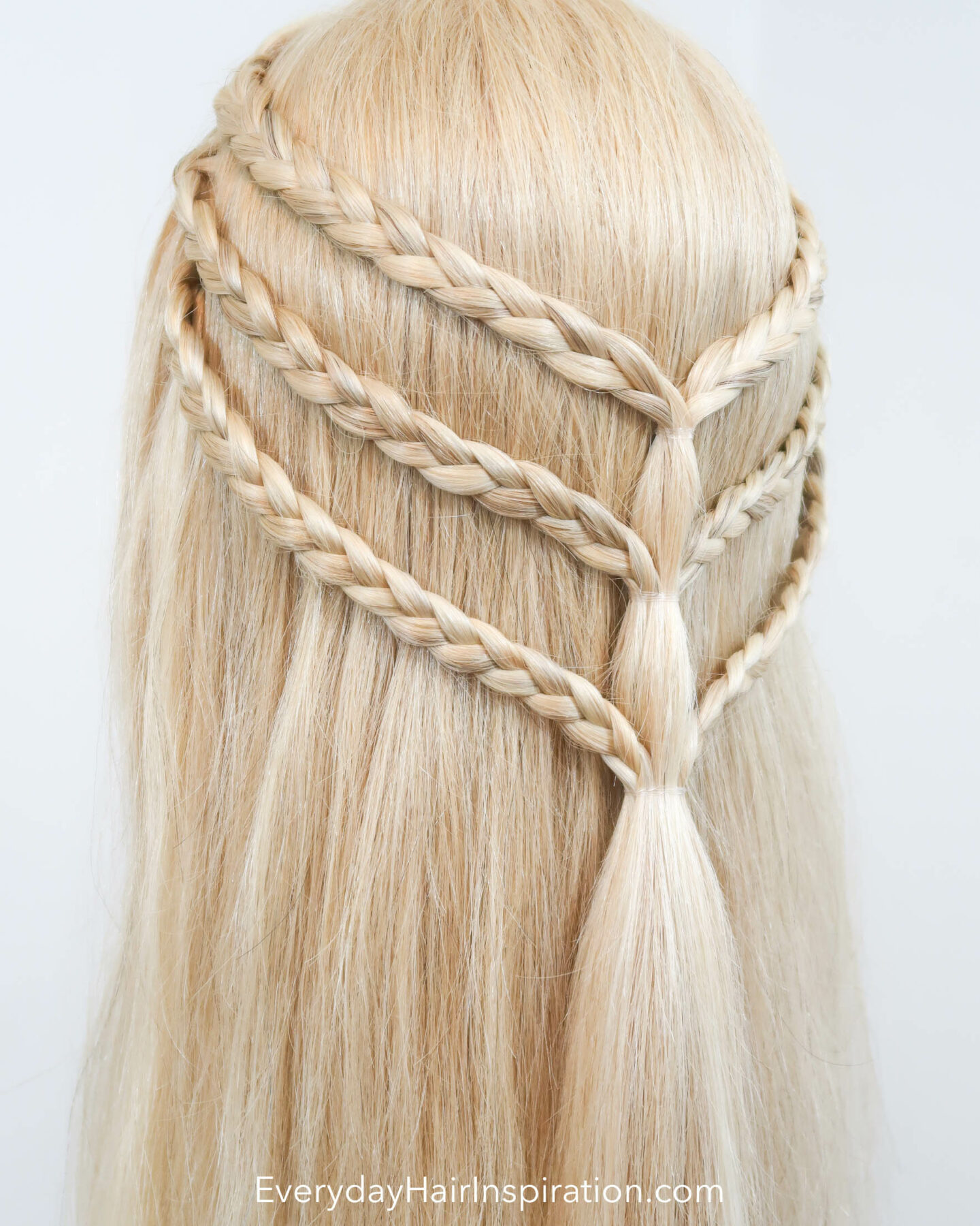 Blonde hairdresser doll with a triple braided half up half down hairstyle seen from the back at an angle