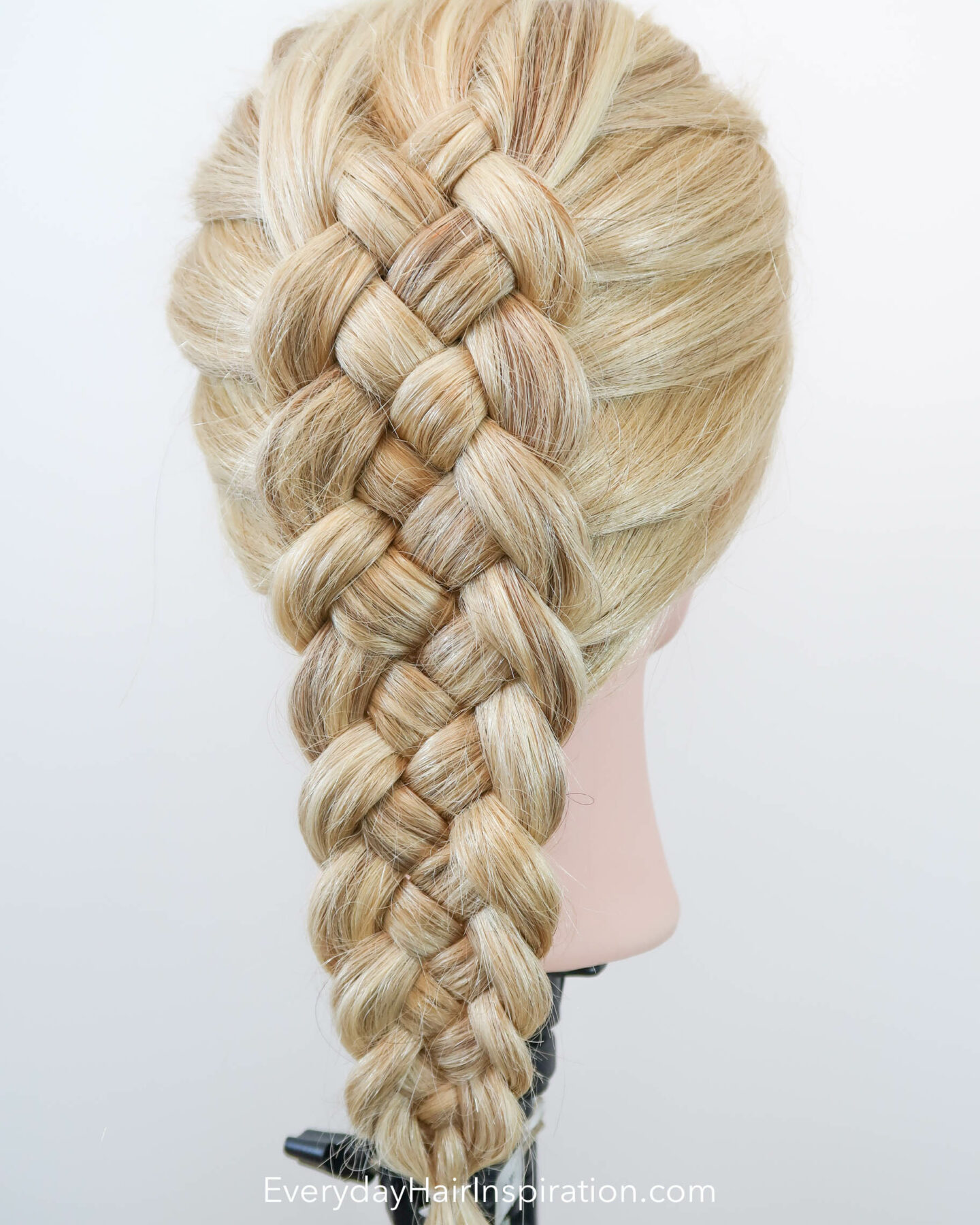 Blonde hairdresser doll with the hair styled into a dutch 5 strand braid, seen from an angle.