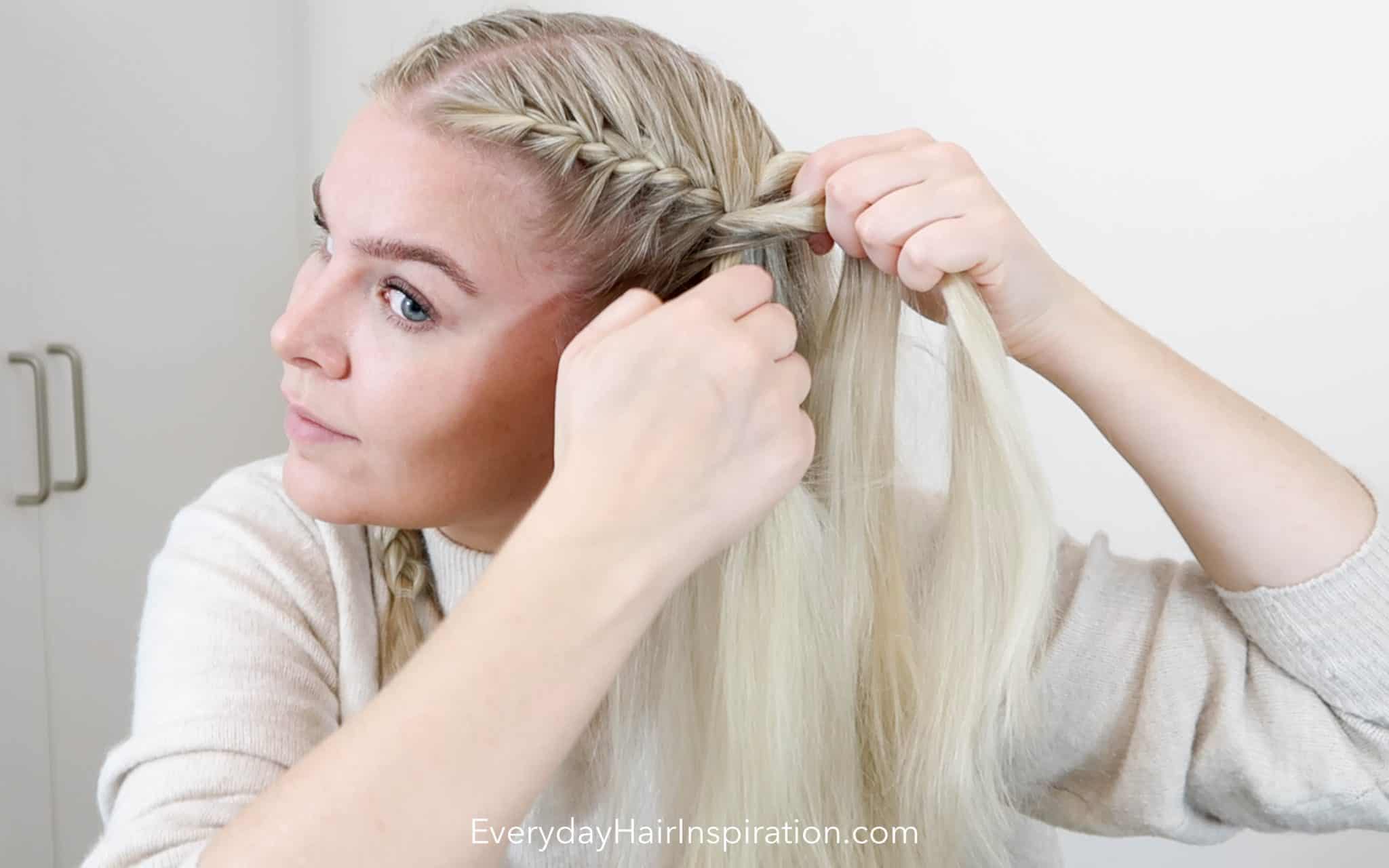 A woman successfully double French braiding her own hair