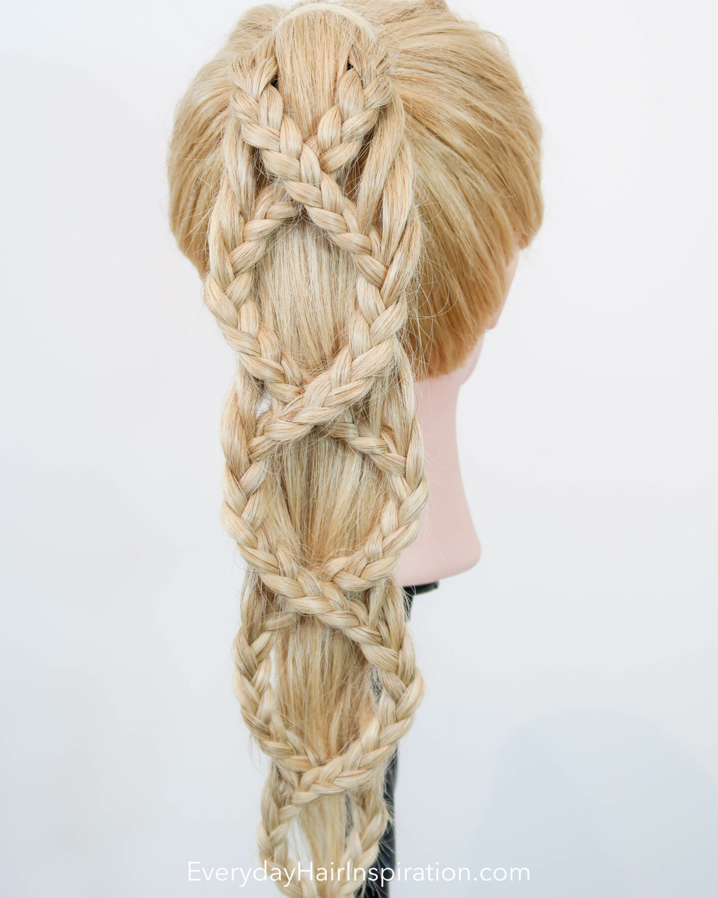 Blonde hair dresser doll seen dorm the back at an angle with a criss-cross braided ponytail.