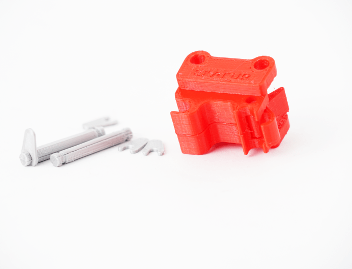 Quick coupler for the VOLVO EC160E (1:16) excavator lying on its side with associated bolts