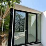 Custom glass garden room with hinged double doors and sandwich panel roof installed by a pool in Dubai and Abu Dhabi villas