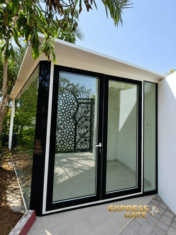 Custom glass garden room with hinged double doors and sandwich panel roof installed by a pool in Dubai and Abu Dhabi villas