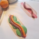 Legeunderlag til udprint med hotdogs. Ketchup, syltede agurker og andet tilbehør er lavet af modellervoks i flotte farver.