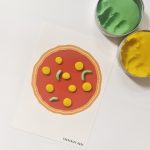 Legeunderlag med pizza. Pizzafyldet er lavet af gul og grøn modellervoks.