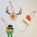 3 juleophæng lavet af træskiver og karton: snemand, Rudolf og julemand.