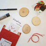 Det kreative kit med juleophæng indeholder 3 x træskiver med hul, snor, vejledning, limstift, sort tusch og klippede kartondele. Pakket i rød pose.