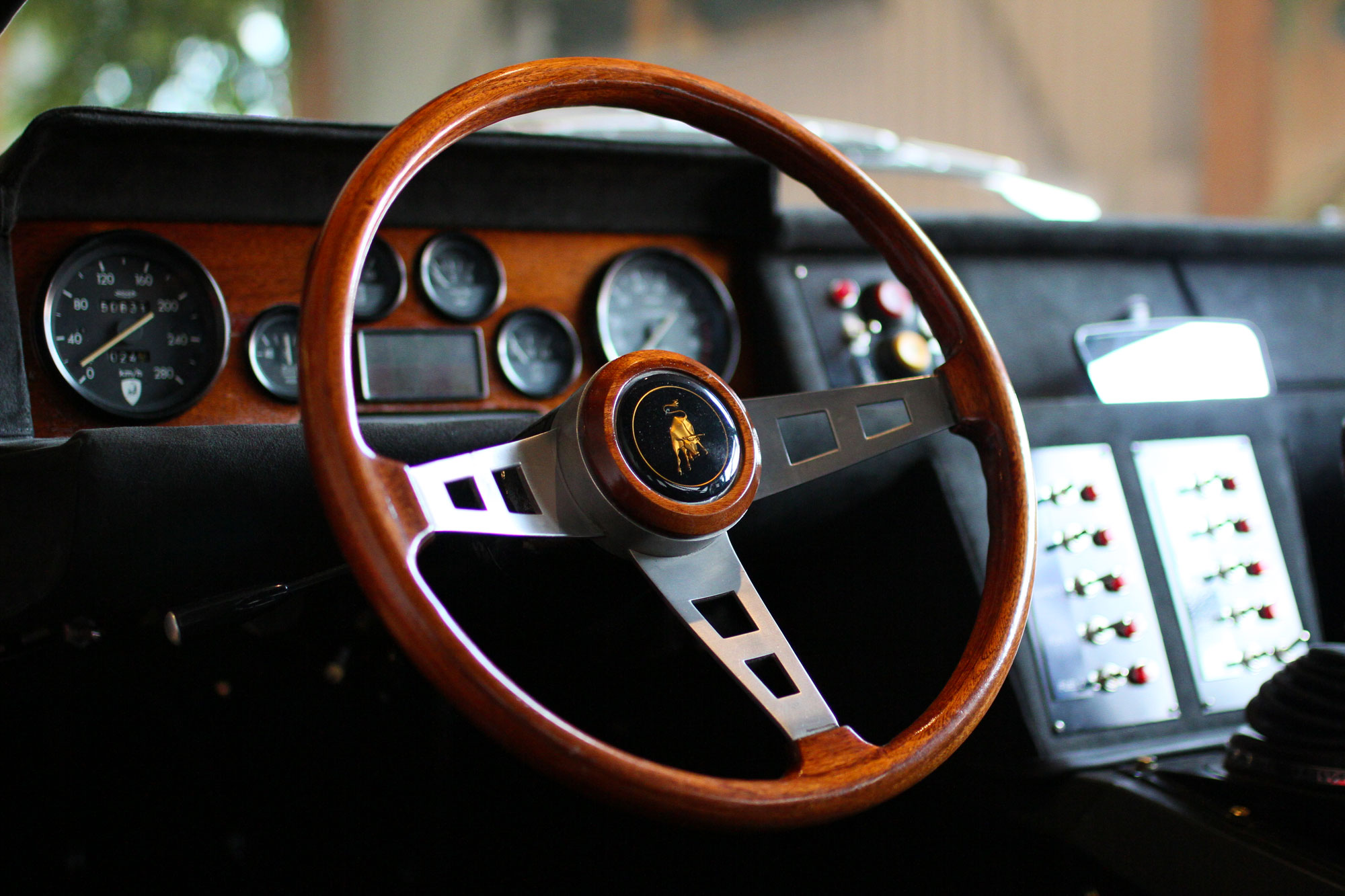 Lamborghini Jaramara Wooden Steering WHeel with all the red buttons in the background