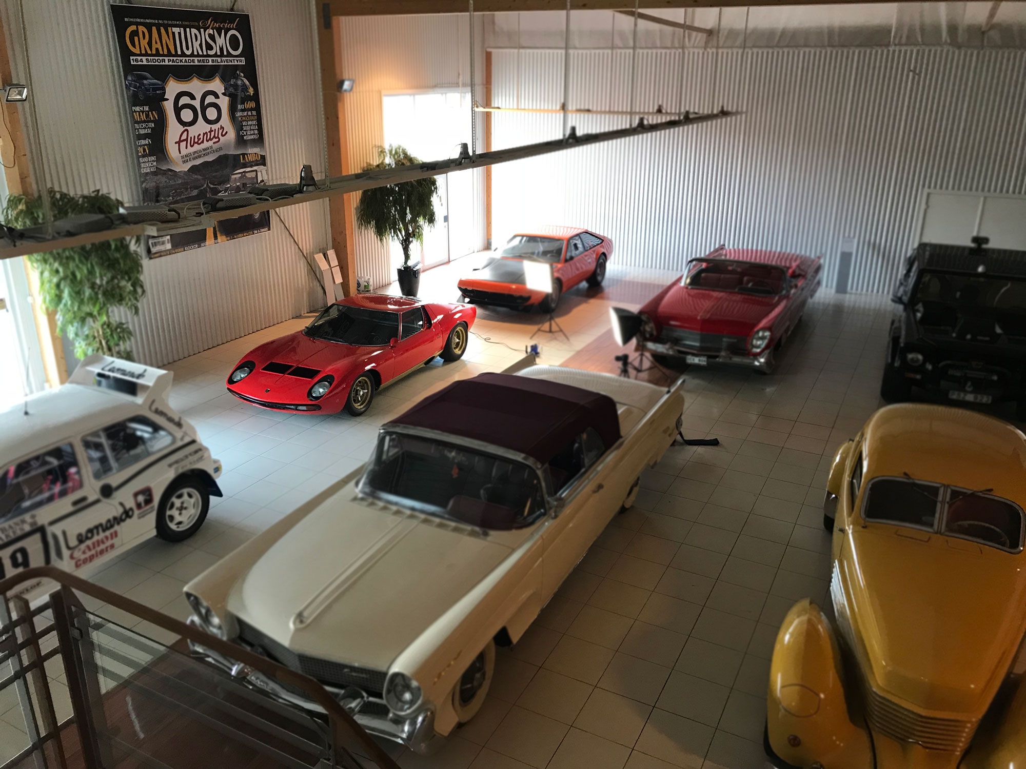 Lamborghini Cocktali garage with a yellow Cord 810, a red and a white Lincoln Continental, a blakc LAmborghini LM002, a red Lamborghini Miura and a orange Lamborghini Jamara