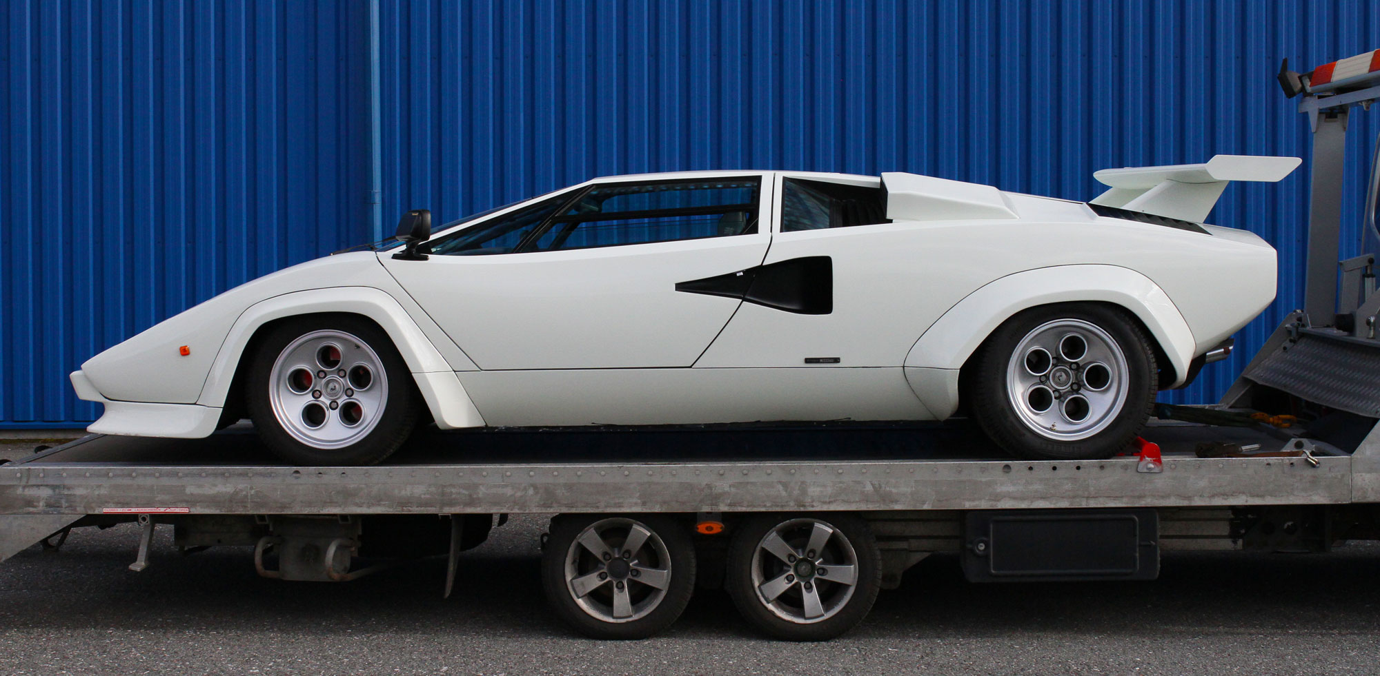 Lamborghini Countach White from Left side infornt of the blue garage house