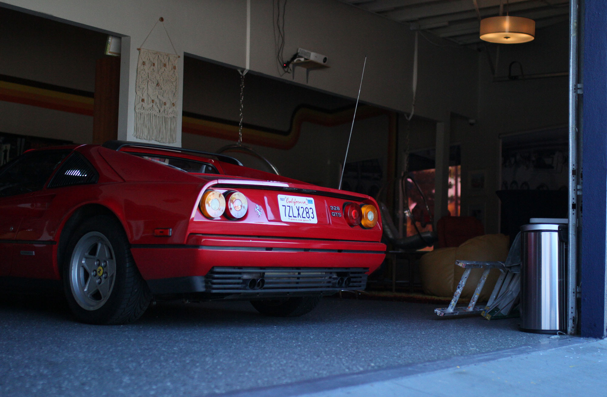 The behind of the Ferrari 328 GTSi inside of the Garage 77 with laters laying on the floor