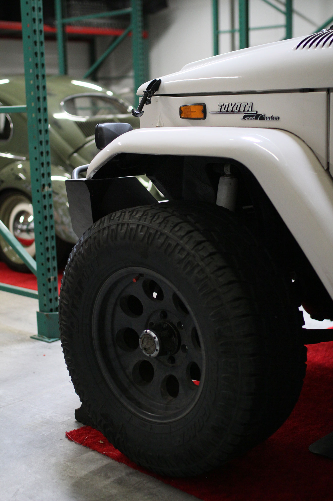 VW Beetle standing in the garage with a white Toyota FJ40