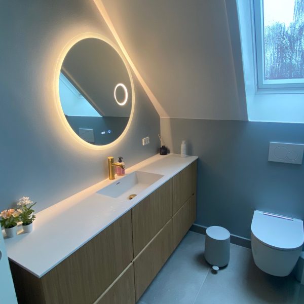 Indretningshjælp til dit bad? Lækkert badeværelse med sarte grønne vægge, specialbygget badmøbel i eg og rundt spejl.