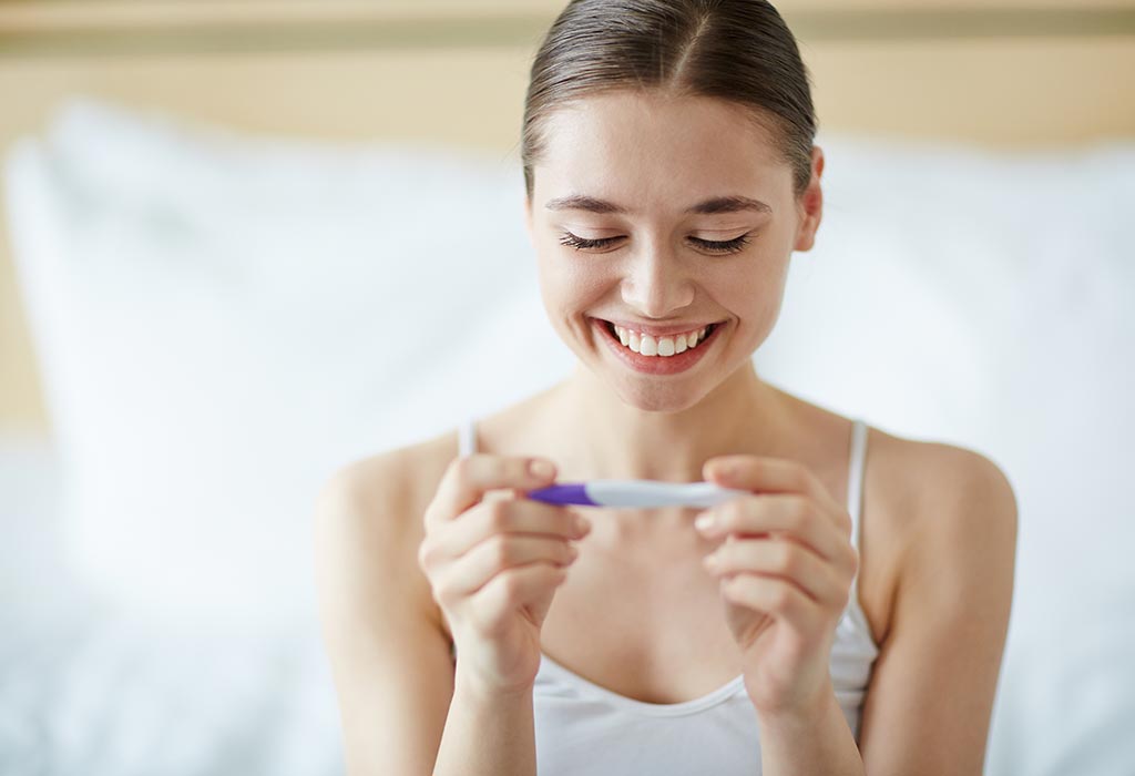 a happy woman looking at the ovulation kit