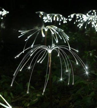 Fiberoptisk lys som ser ut som lysende planter i en hage.