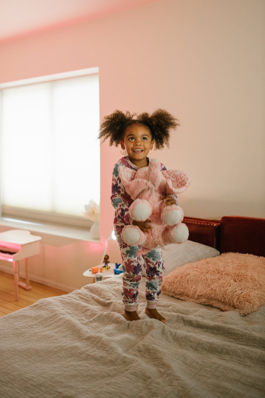 smiling girl on bed with toy