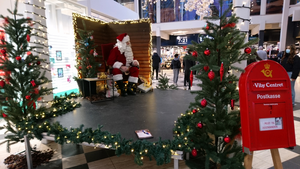 Дед Мороз возле рождественской елки с сосками, принимает украшения для елки от самых маленьких посетителей торгового центра. Фото 11 дек. 2021, г. Вибю / Viby, Дания