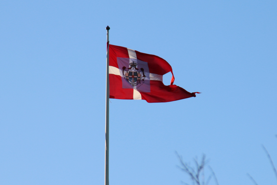 Флаг Даннеброг королевы Маргрете 2 над крышей дворца Марселисборг, г. Орхус, Дания. Фото 24 дек. 2021