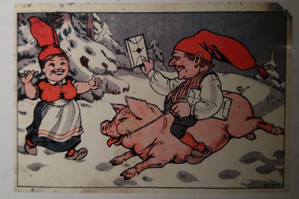 Старая открытка ниссе на свинье с рождественским подарком в заснеженном лесу