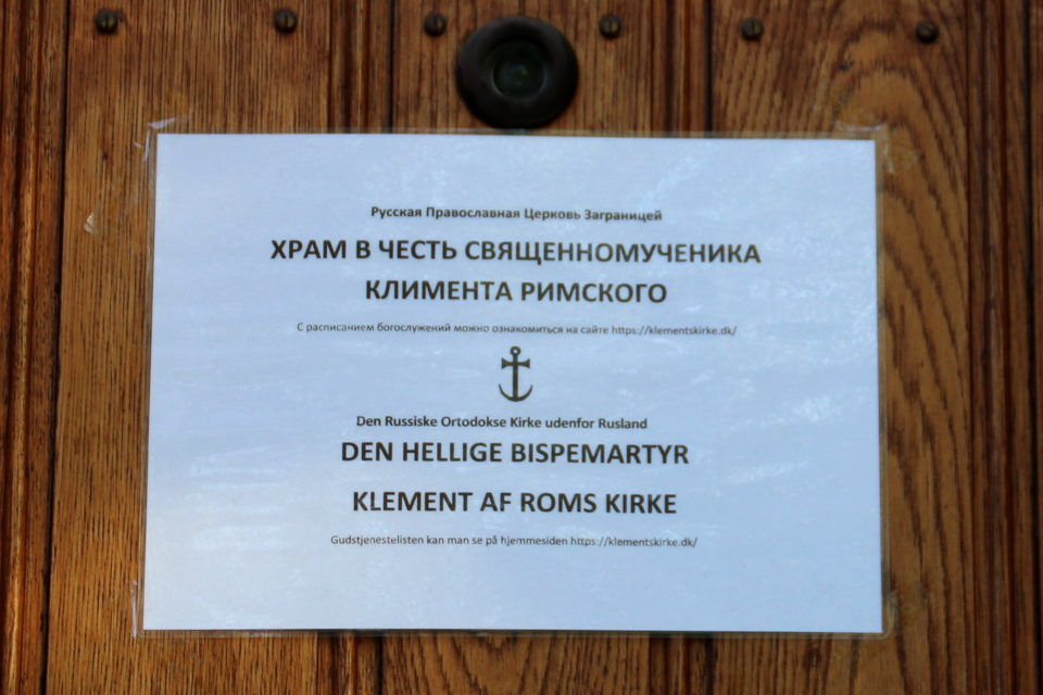 Информационная табличка на входной двери в Храм св. Климента Римского в Орхусе (Hl. Klement af Roms kirke i Aarhus) - бывший дом священника в Вибю. Фото 20 мая 2021, г. Вибю (Орхус), Дания