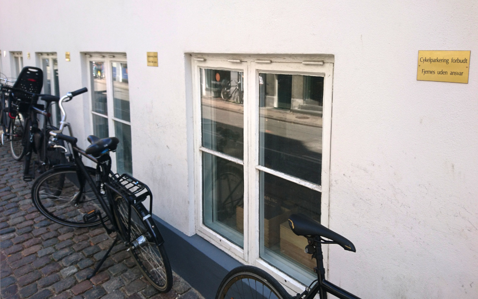 Табличи про запреты на парковку возле каждого окна нижнего этажа здания недалеко от здания парламента. Фото 9 июня 2023, Копенгаген, Дания.
