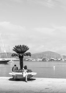 Girl in the Alghero harbor checking her phone