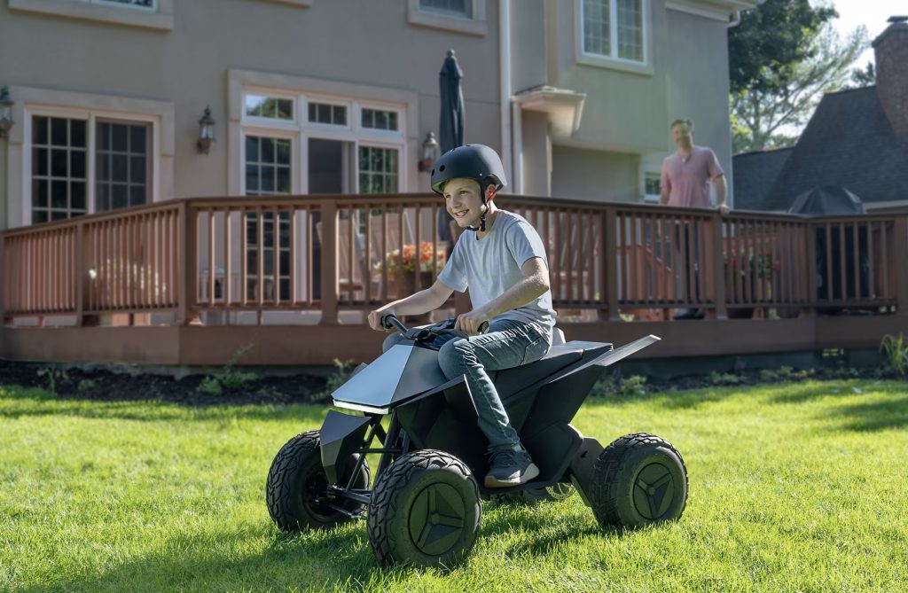 Ett barn som kör Cyberquad på en gräsmatta.