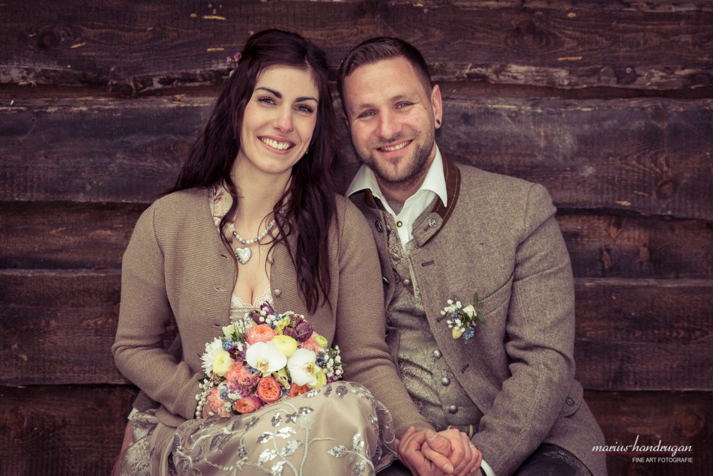 Brautpaar-Shooting in Tracht vor einer Holzwand