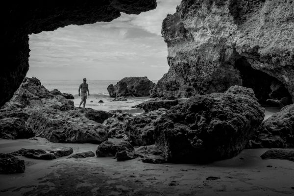Enslig mann på safari i grottelandskapet du finner så mye av langs sørkysten av Portugal. Her fra en strand like utenfor Albufeira.