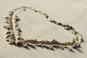 Symbolsk hjerte i sanden.