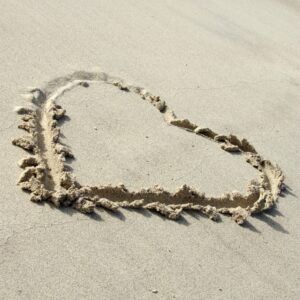 Symbolsk hjerte i sanden.