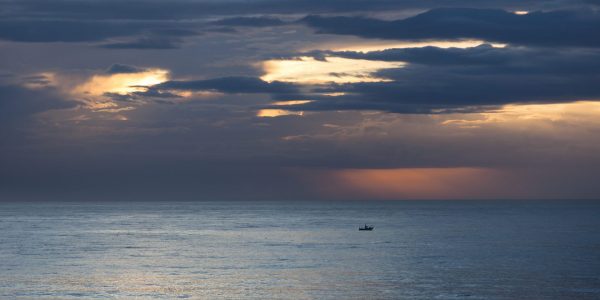 Et majestetisk lys over havet når dagen gryr over Costa del Sol og enslig fiskebåt er ute på jakt etter dagens fangst.