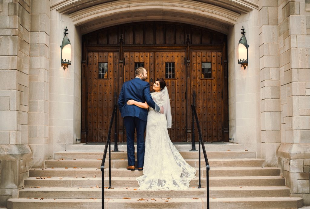 Photo mariage, les mariés sur les marches de l'église.