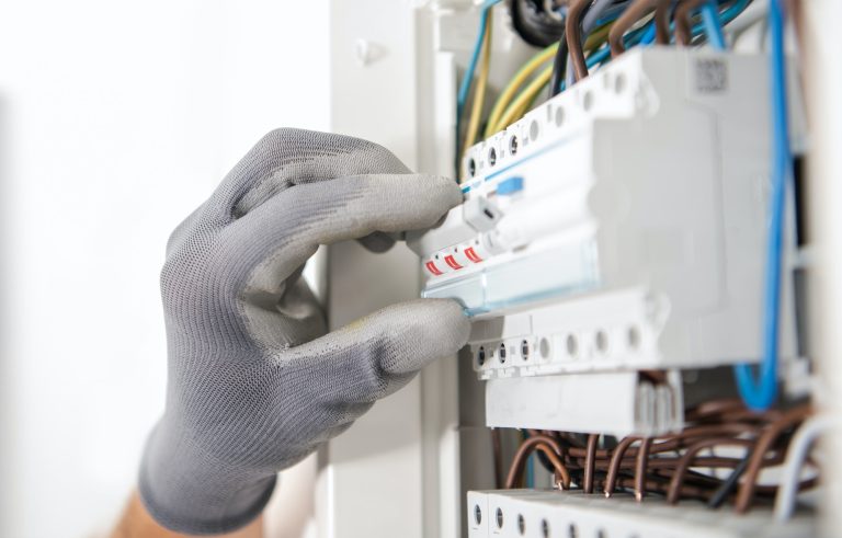 Electrician Testing Fuses In the Electric Box