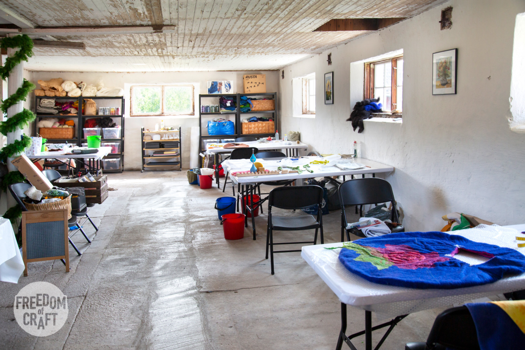 The atelier at Böle textile farm. A long room with tables at both sides of an isle, giving students plenty of work space.